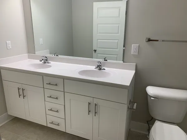 a bathroom with a toilet a sink and mirror