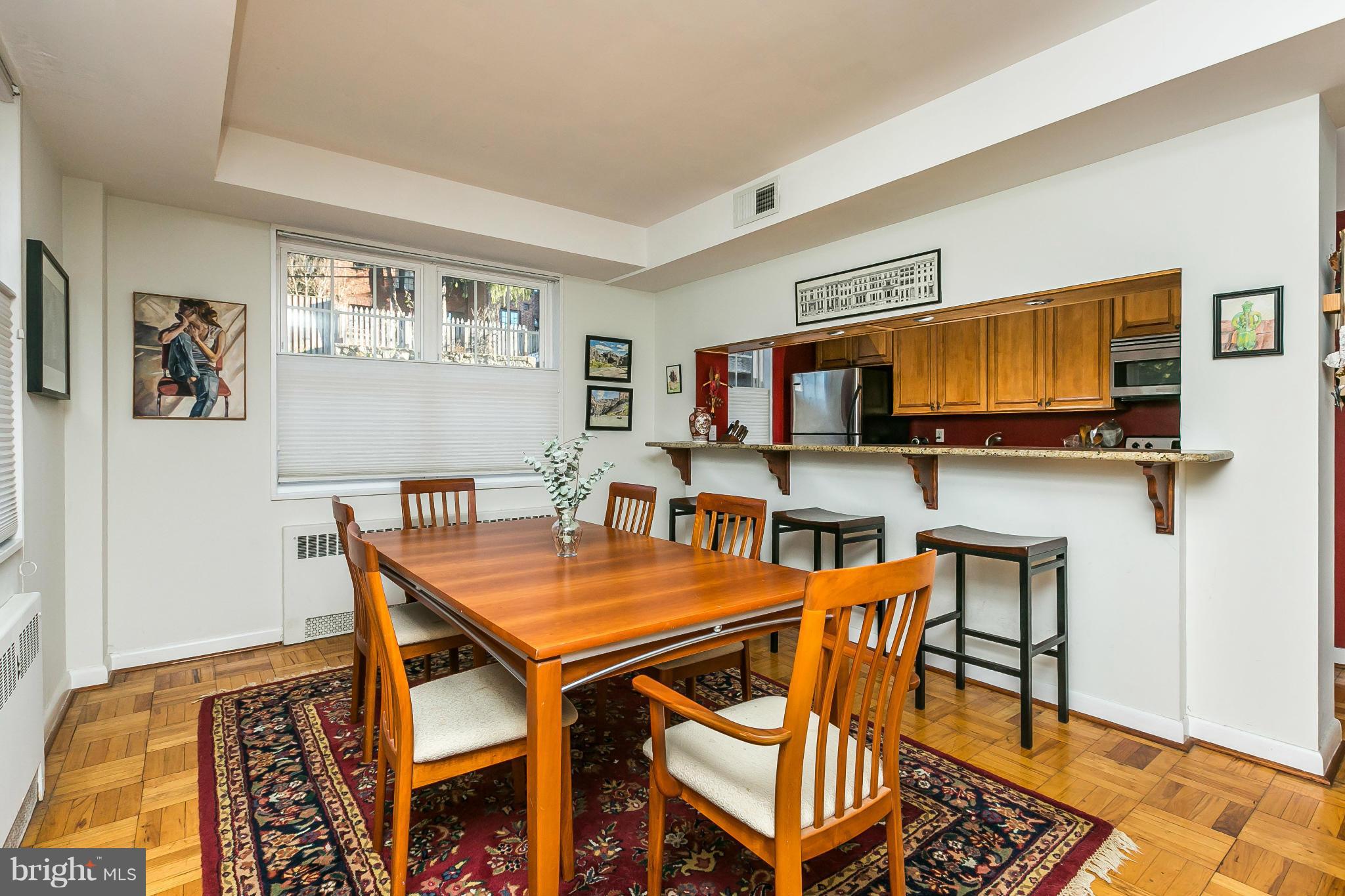 310 Ridgemede Road, Unit 107 Baltimore, MD 21210 - Photo 15 of 28 a view of a dining room with furniture and wooden floor