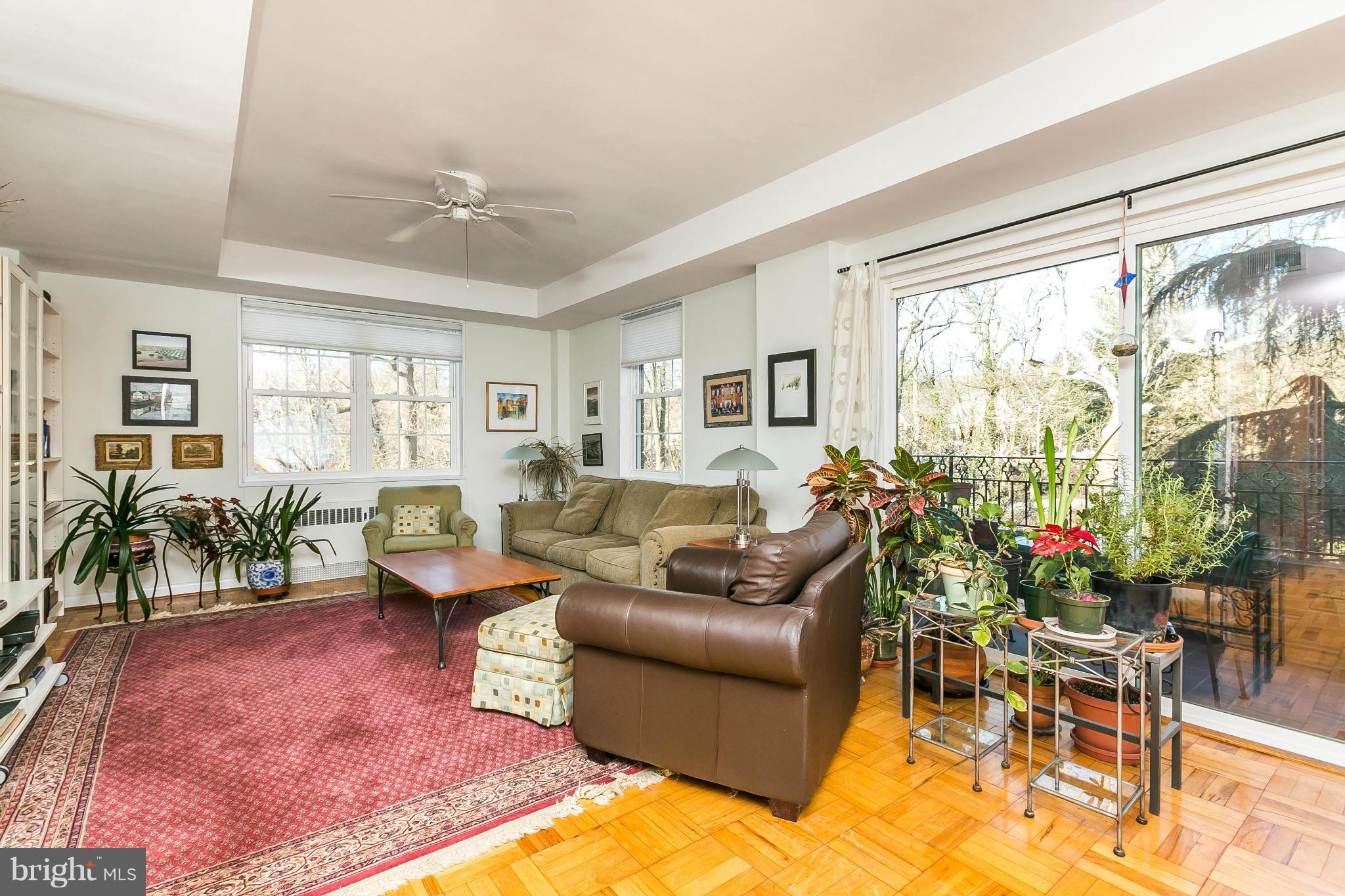 310 Ridgemede Road, Unit 107 Baltimore, MD 21210 - Photo 18 of 28 a living room with furniture potted plant and a large window