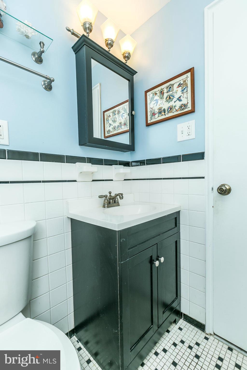 310 Ridgemede Road, Unit 107 Baltimore, MD 21210 - Photo 26 of 28 a bathroom with a sink mirror and toilet
