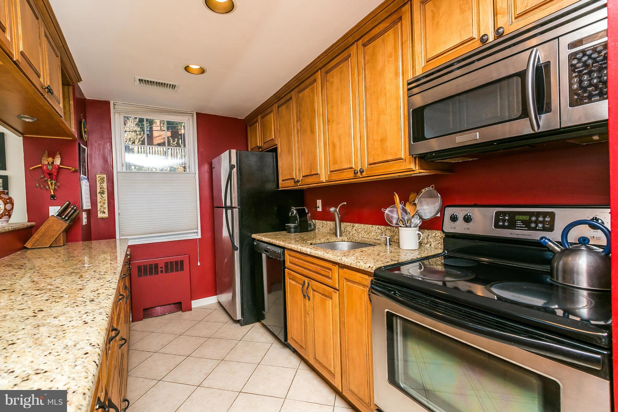 310 Ridgemede Road, Unit 107 Baltimore, MD 21210 - Photo 9 of 28 a kitchen with stainless steel appliances granite countertop a stove and a microwave