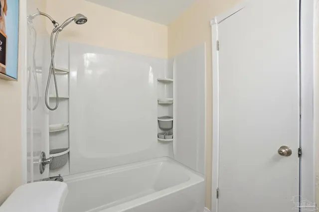a bathroom with a granite countertop bathtub shower and toilet