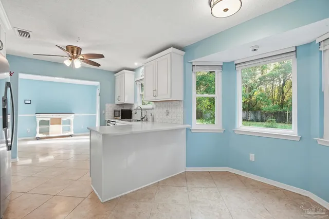 a living room with stainless steel appliances kitchen island furniture and a chandelier