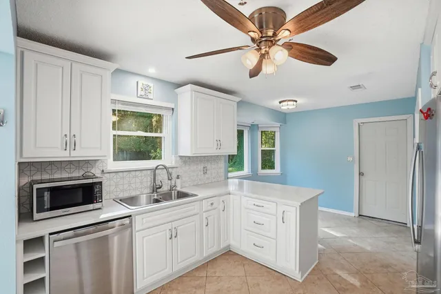 a kitchen with cabinets stainless steel appliances a sink and a window