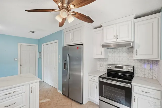 a kitchen with stainless steel appliances a stove a refrigerator and cabinets