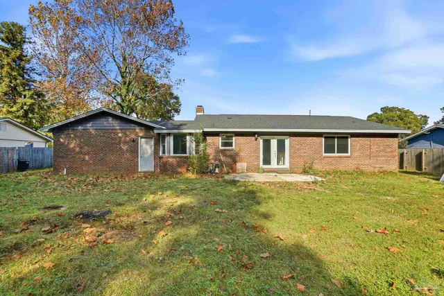 a view of a yard in front of a house with large trees