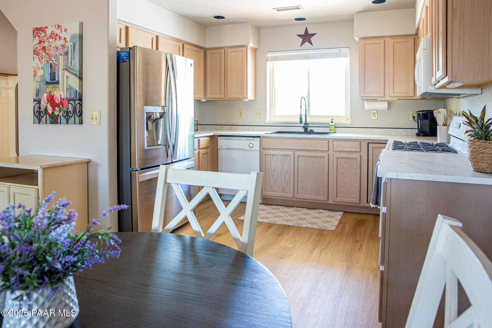 7075 Horizon Way Prescott Valley, AZ 86315 - Photo 19 of 44 a kitchen with granite countertop a refrigerator a sink dishwasher and white cabinets with wooden floor