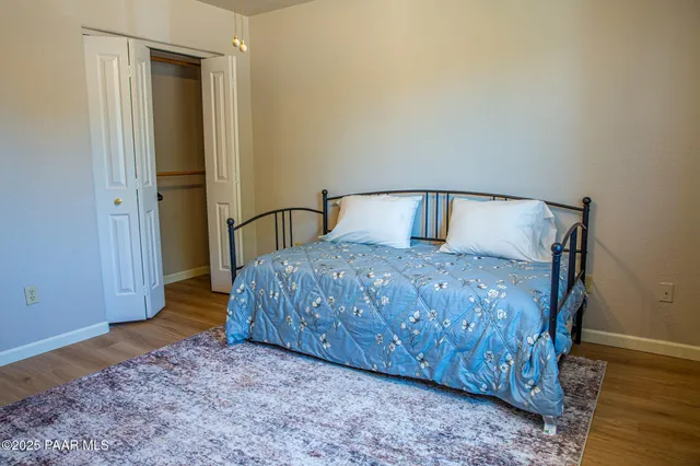 a bedroom with a bed and wooden floor