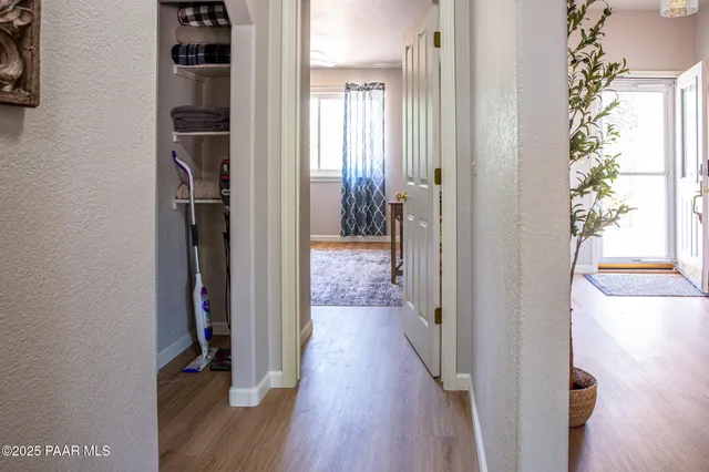 a view of a hallway with wooden floor and staircase