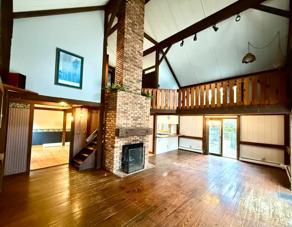 a living room with furniture a fireplace and a floor to ceiling window