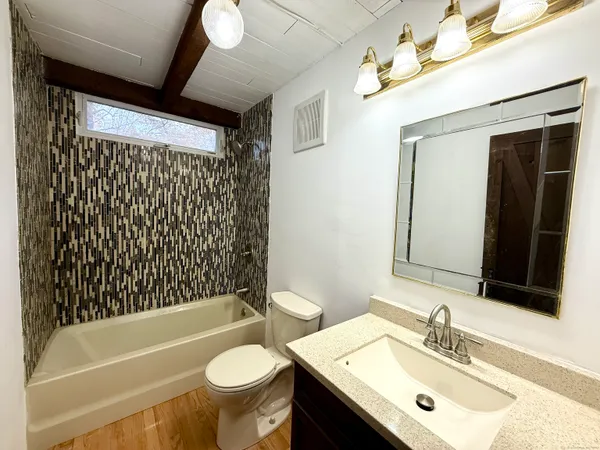 an empty room with wooden floor and windows with curtains