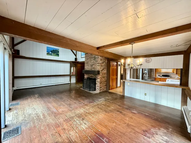 a large kitchen with stainless steel appliances wooden cabinets a oven and a large window