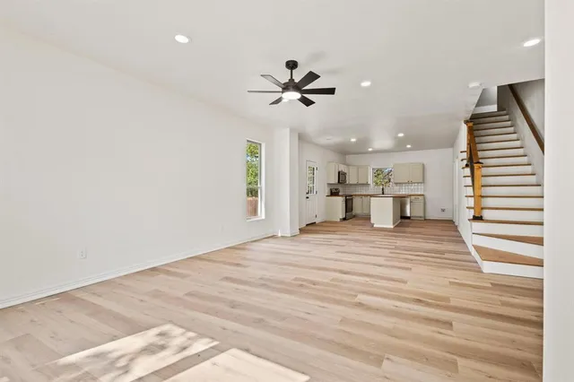 a view of a room with a ceiling fan and wooden floor