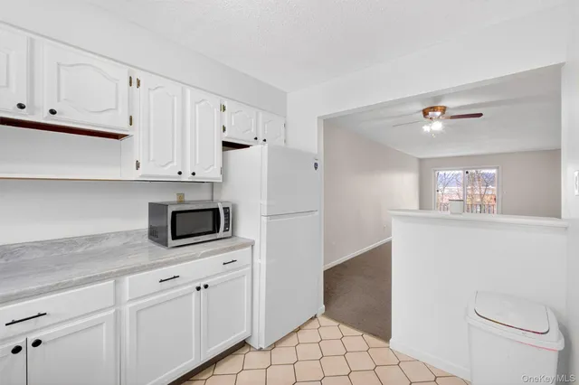 a kitchen with white cabinets and white appliances