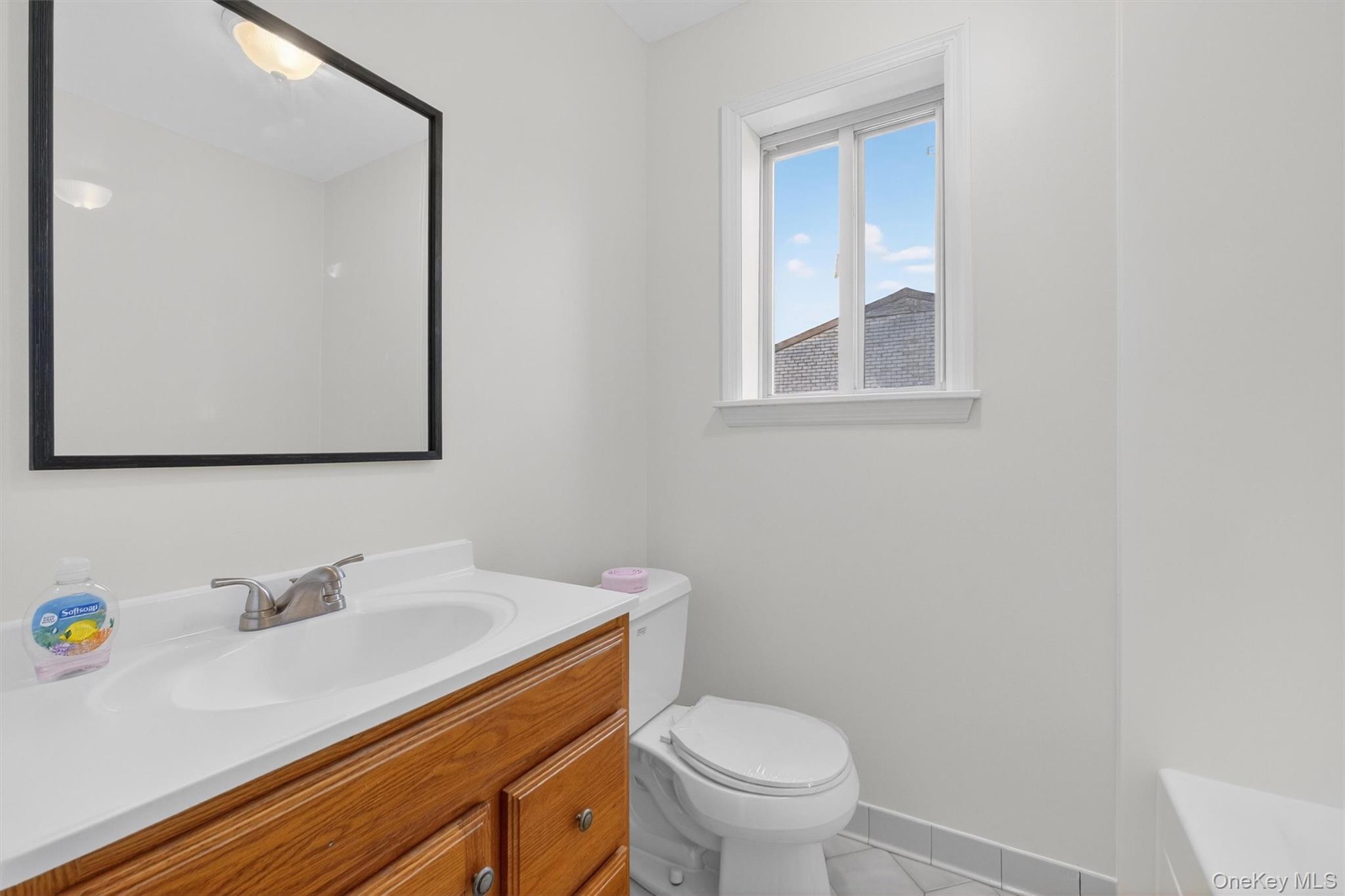 26 Cooper Road, Unit 715 Poughkeepsie, NY 12603 - Photo 21 of 28 a bathroom with a sink a toilet and mirror