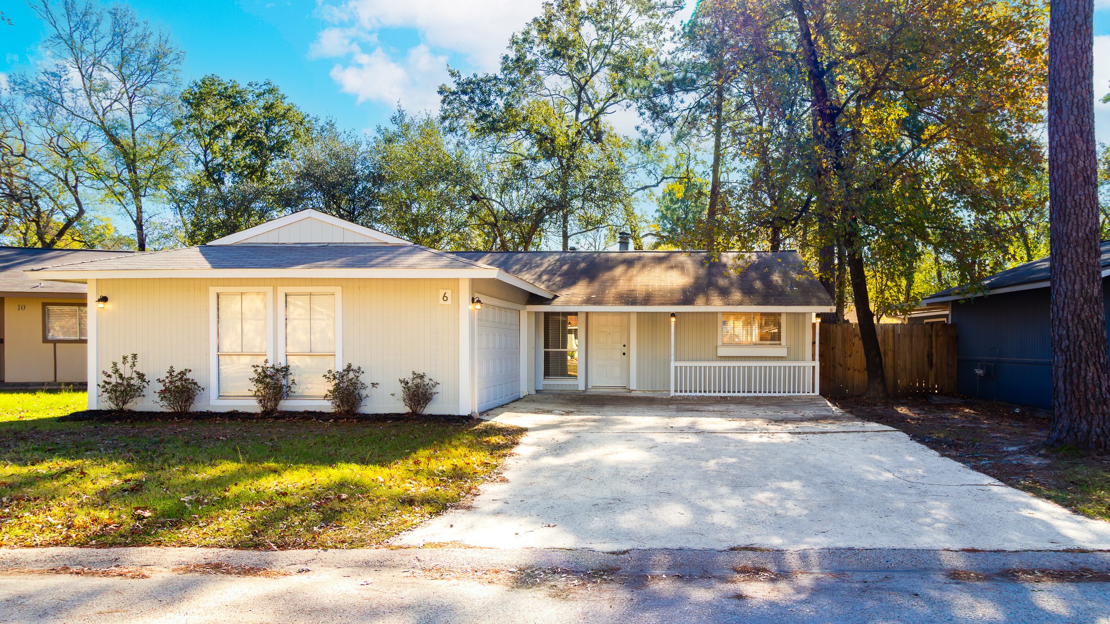 a front view of a house with a yard and large trees