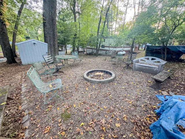 a backyard of a house with fire pit and outdoor seating