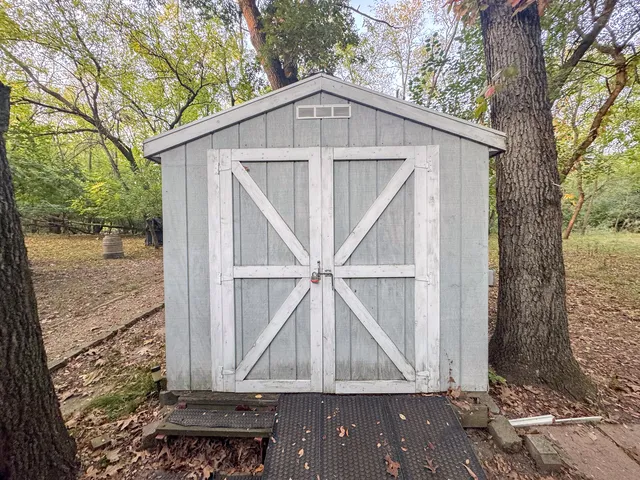 a white house covered with tall trees