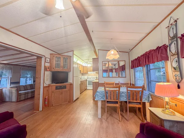 a dining room with furniture a floor to ceiling window and wooden floor