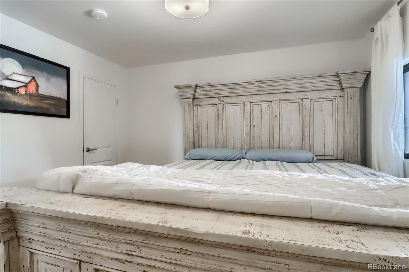 4175 West Custer Place Denver, CO 80219 - Photo 23 of 38 a bedroom with a bed and a chandelier