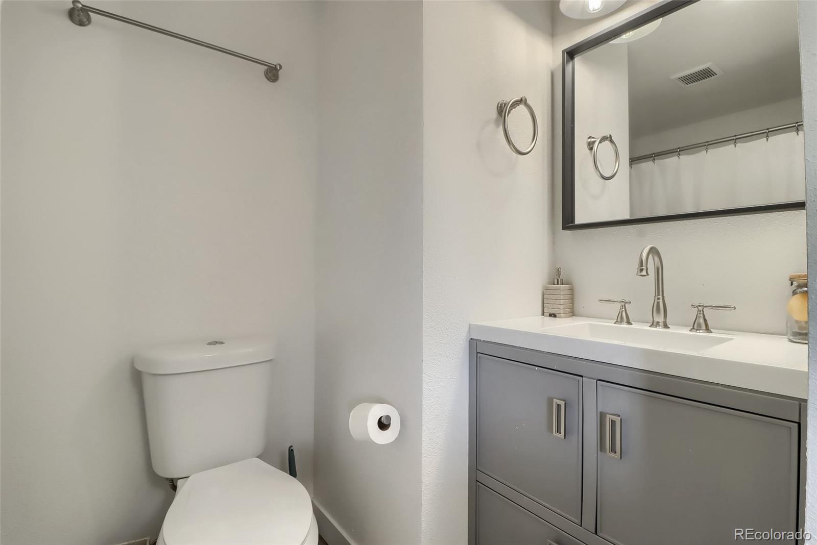 4175 West Custer Place Denver, CO 80219 - Photo 25 of 38 a bathroom with a toilet a sink and mirror
