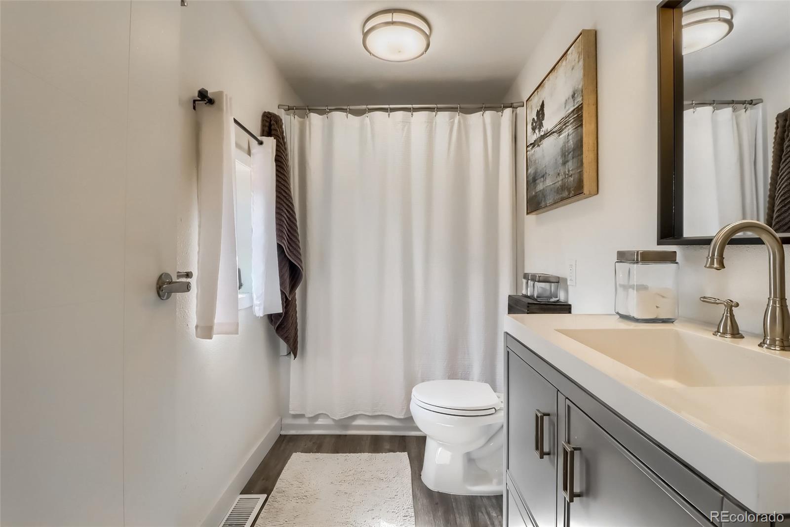 4175 West Custer Place Denver, CO 80219 - Photo 32 of 38 a bathroom with a sink toilet and shower
