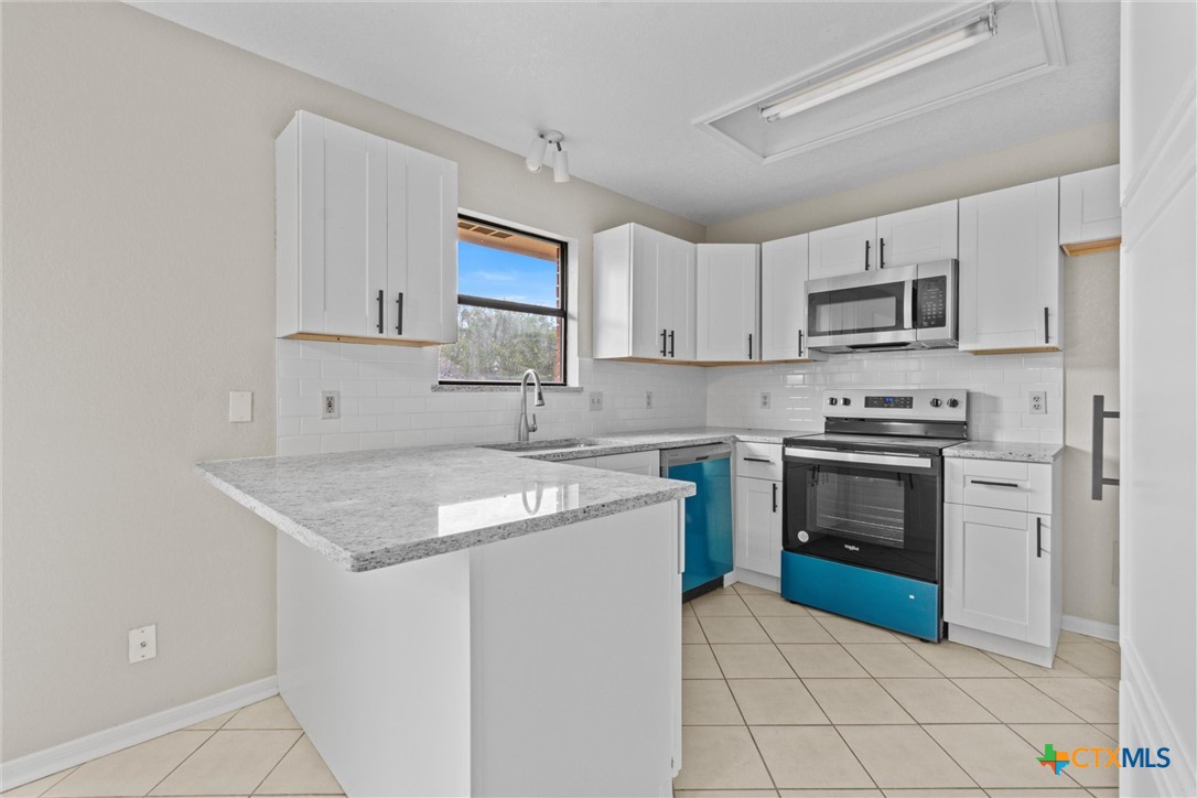 180 County Road 4933 Kempner, TX 76539 - Photo 7 of 24 a kitchen with stainless steel appliances granite countertop a sink stove microwave and cabinets