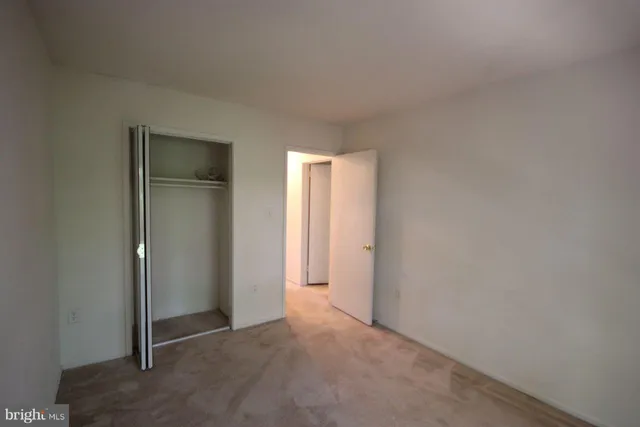 a view of an empty room and closet area