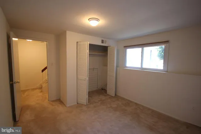 an empty room with windows and closet