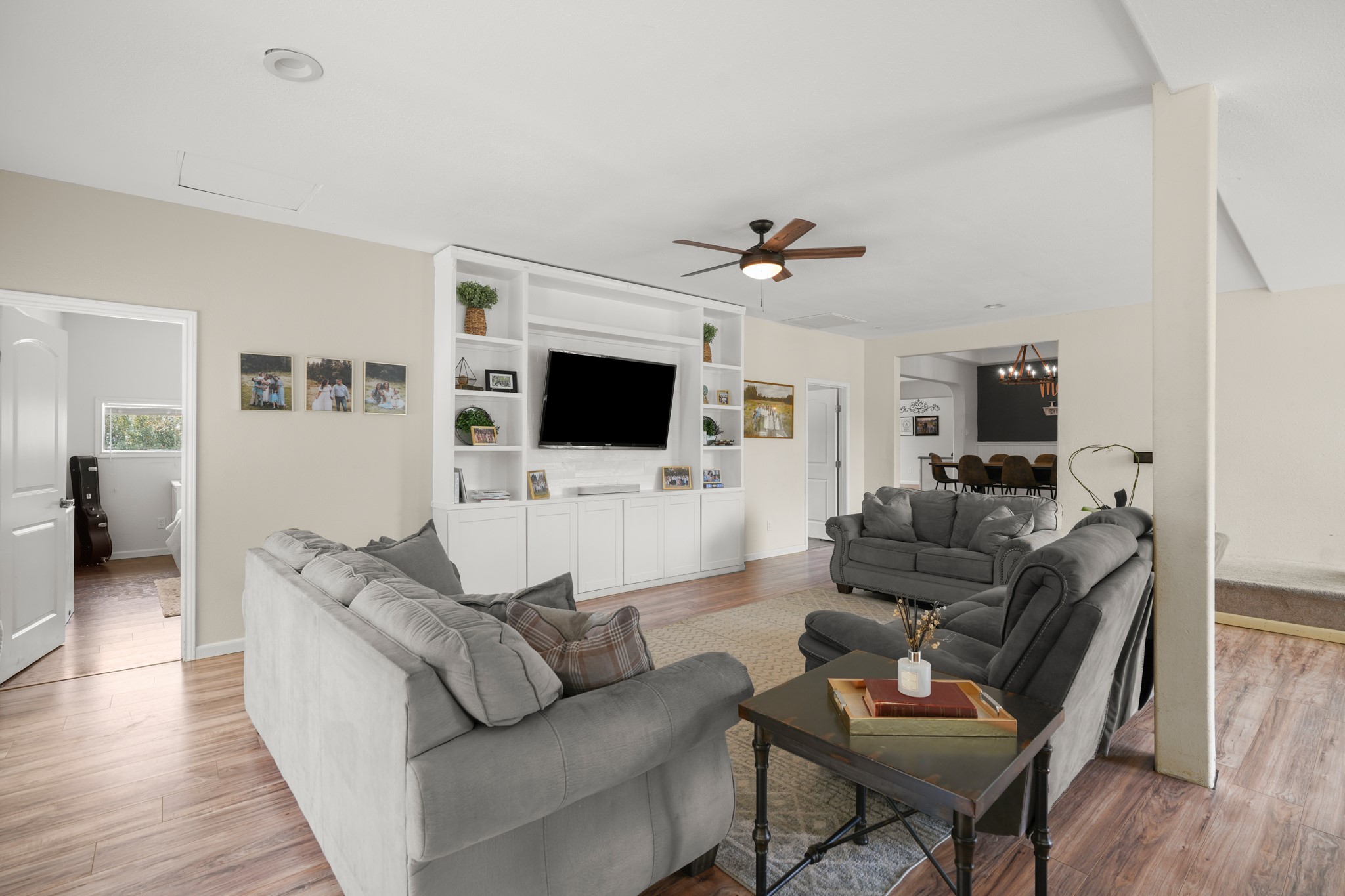 9725 Bock Road Buda, TX 78610 - Photo 7 of 32 A welcoming living area offers built-in shelving, a ceiling fan, and seamless flow into an adjacent dining space.