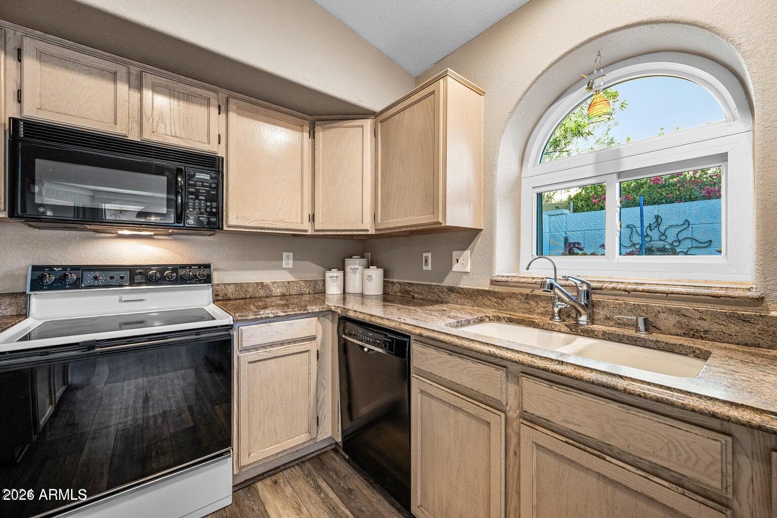 473 West Smoke Tree Road Gilbert, AZ 85233 - Photo 16 of 43 a kitchen with granite countertop a sink a stove and cabinets