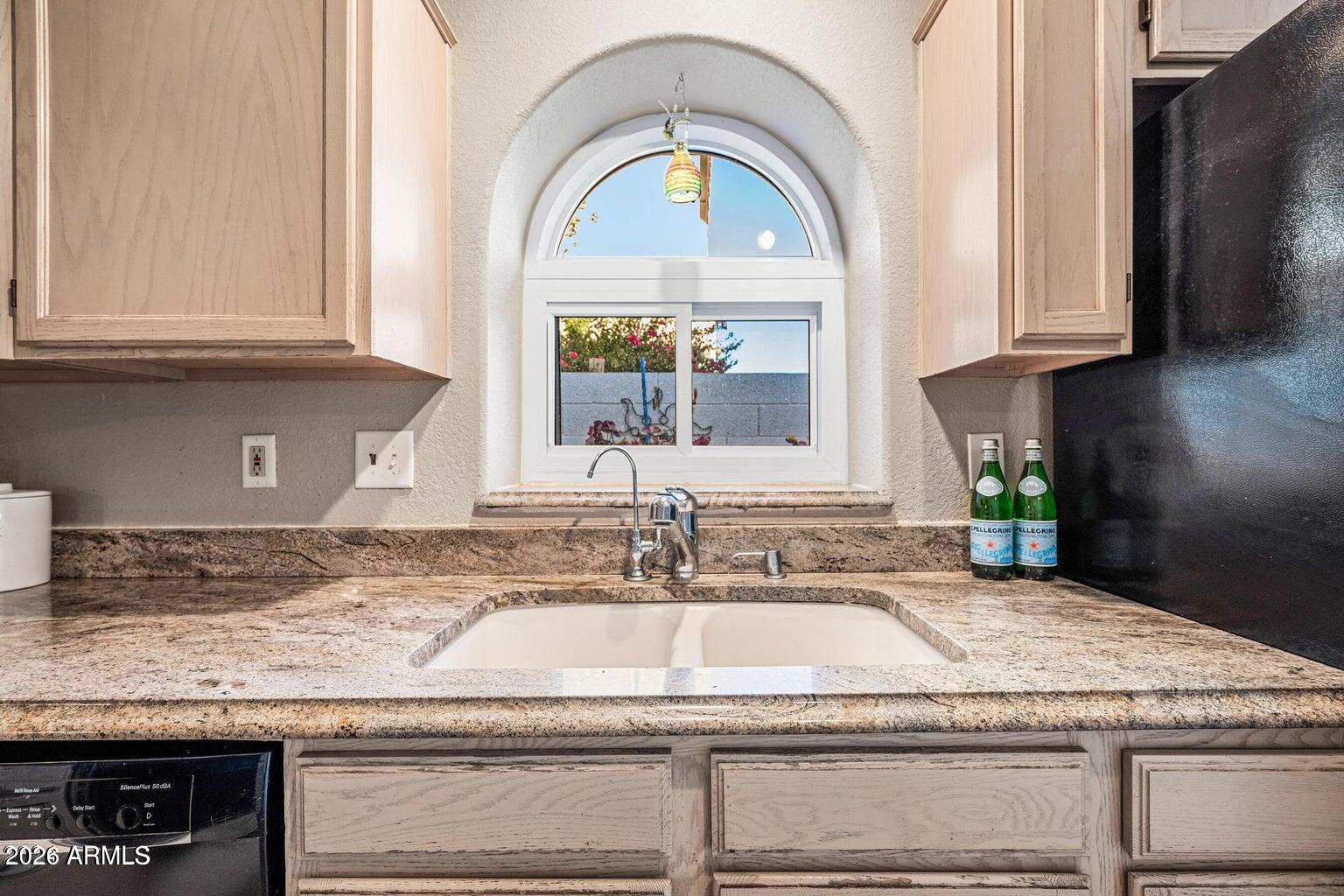 473 West Smoke Tree Road Gilbert, AZ 85233 - Photo 17 of 43 a kitchen with granite countertop a sink stainless steel appliances white cabinets and a window