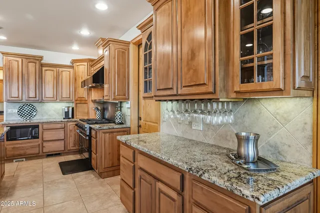 a kitchen with stainless steel appliances granite countertop a stove a sink and a microwave