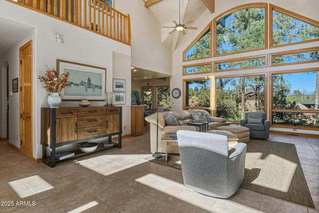 a living room with fireplace furniture and a large window