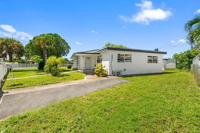 a view of a house with backyard and a tree
