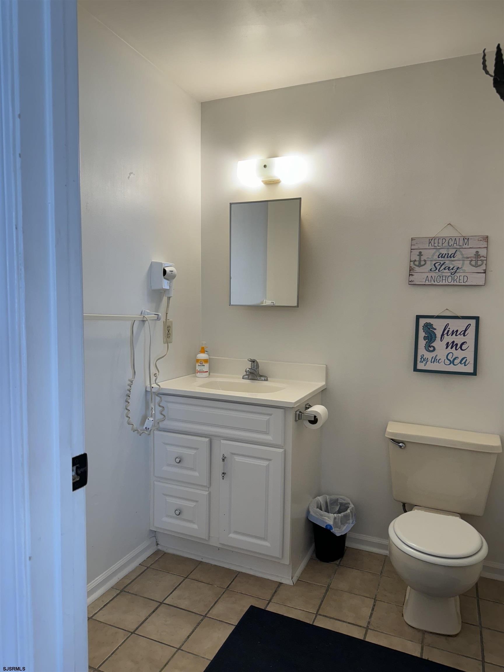 407 36th Street South, Unit 2 Brigantine, NJ 08203 - Photo 13 of 30 a bathroom with a toilet sink and mirror