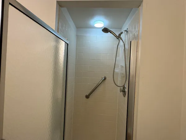 a bathroom with a glass shower door and mirror