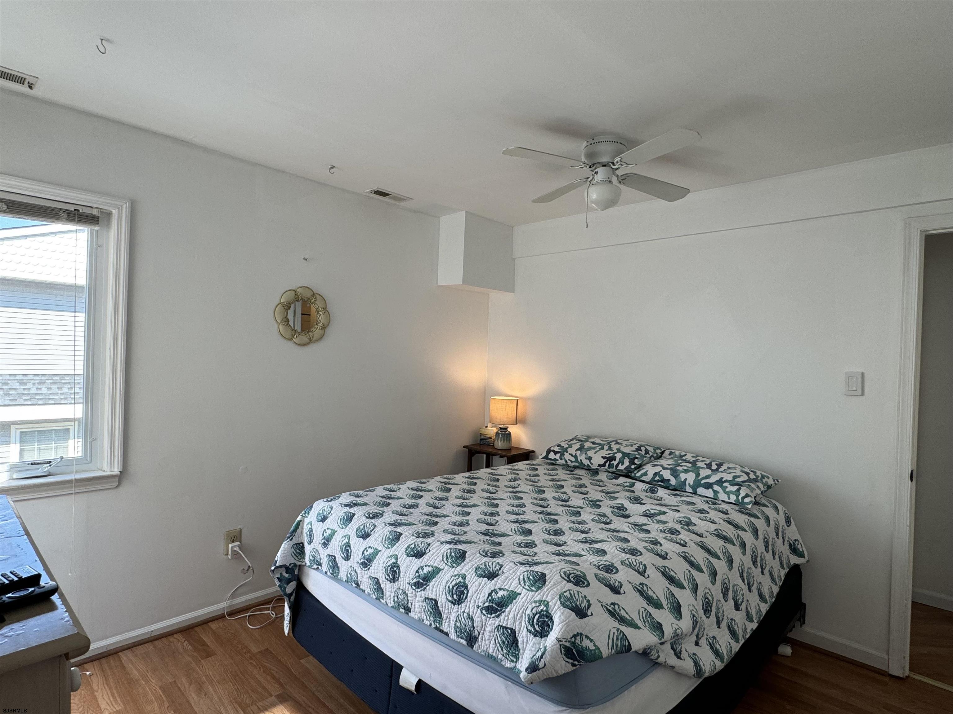 407 36th Street South, Unit 2 Brigantine, NJ 08203 - Photo 18 of 30 a bedroom with a bed and wooden floor