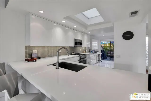 a kitchen with a refrigerator a stove a sink dishwasher with a dining table and chairs