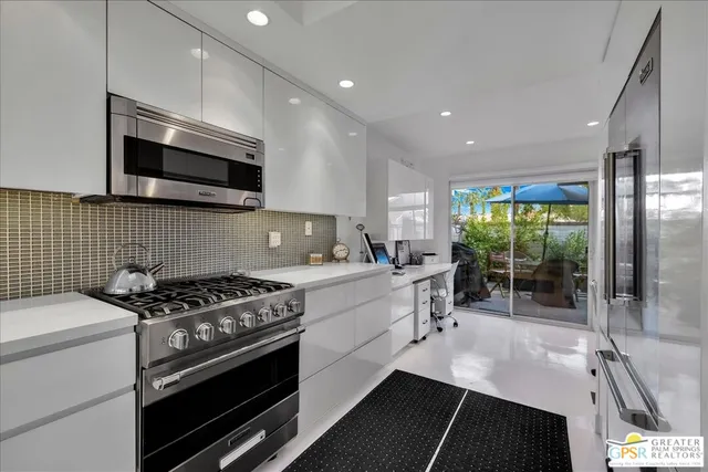 a kitchen with stainless steel appliances a stove sink microwave and cabinets