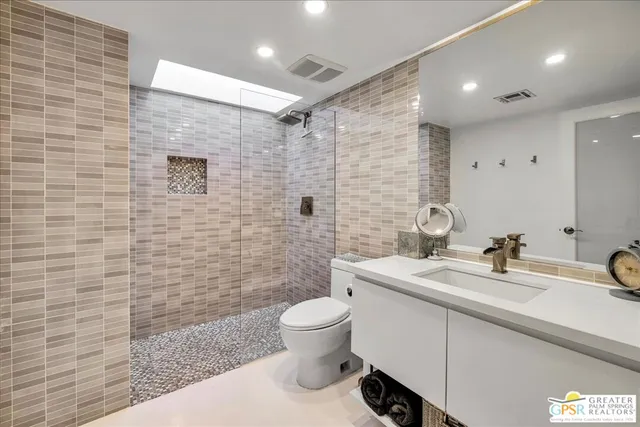 a bathroom with a sink a toilet and mirror