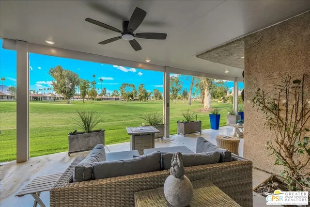a living room with patio furniture and a garden