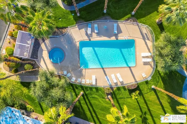 an aerial view of a swimming pool with a yard
