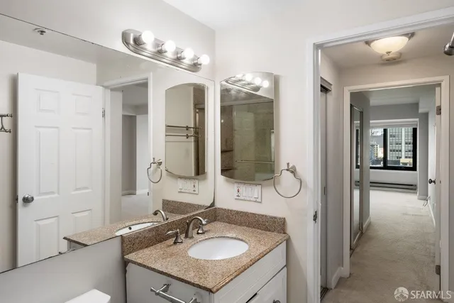 a bathroom with a sink vanity granite and a mirror