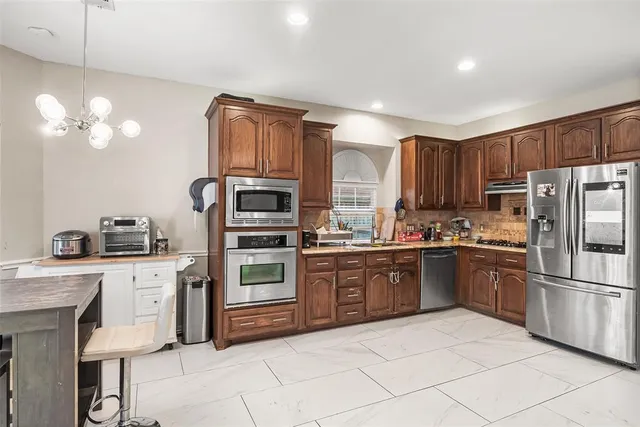 a kitchen with stainless steel appliances granite countertop a refrigerator and a sink