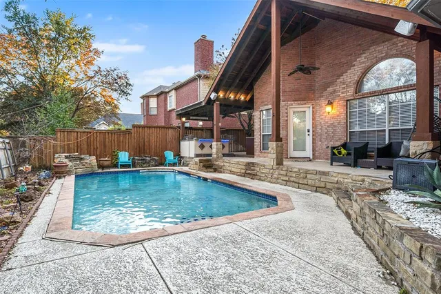 a view of a backyard with a small pool and sitting area