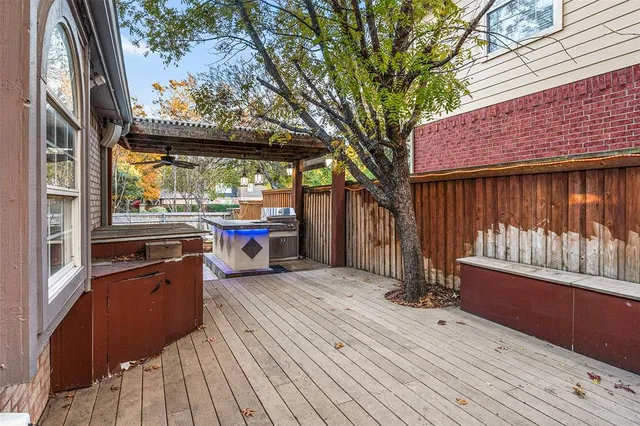 a view of a backyard with wooden fence and a large tree