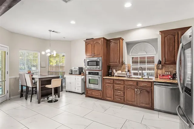 a kitchen with granite countertop a refrigerator stove top oven and sink