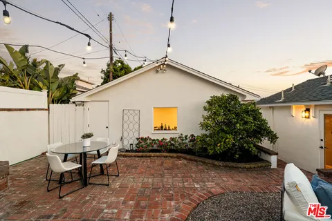 a backyard of a house with table and chairs