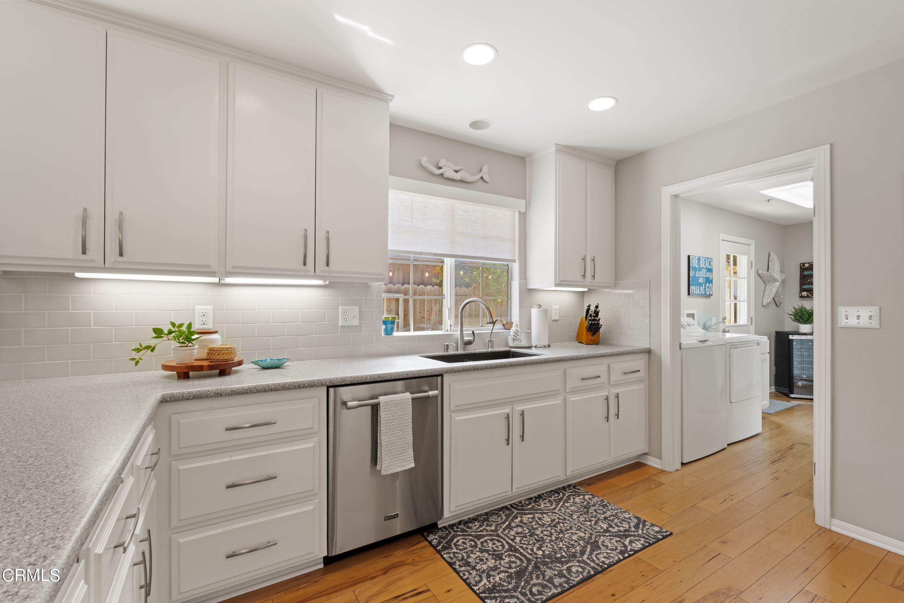 10975 Darling Road Ventura, CA 93004 - Photo 15 of 49 a kitchen with granite countertop white cabinets and white appliances